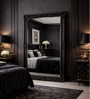 Dark-themed bedroom with a large mirror reflecting the bed and decor.